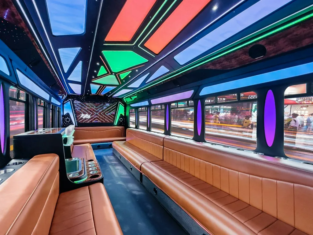 image of 28 passenger Party Bus lit interior taken from side bench seat near front door